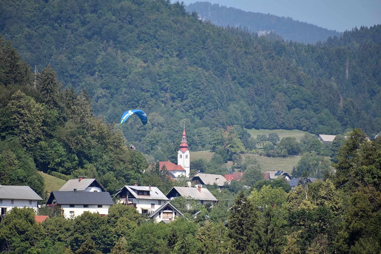 Občina Gorje Vas pod gozdnatim pobočjem z zvonikom in jadralnim padalom